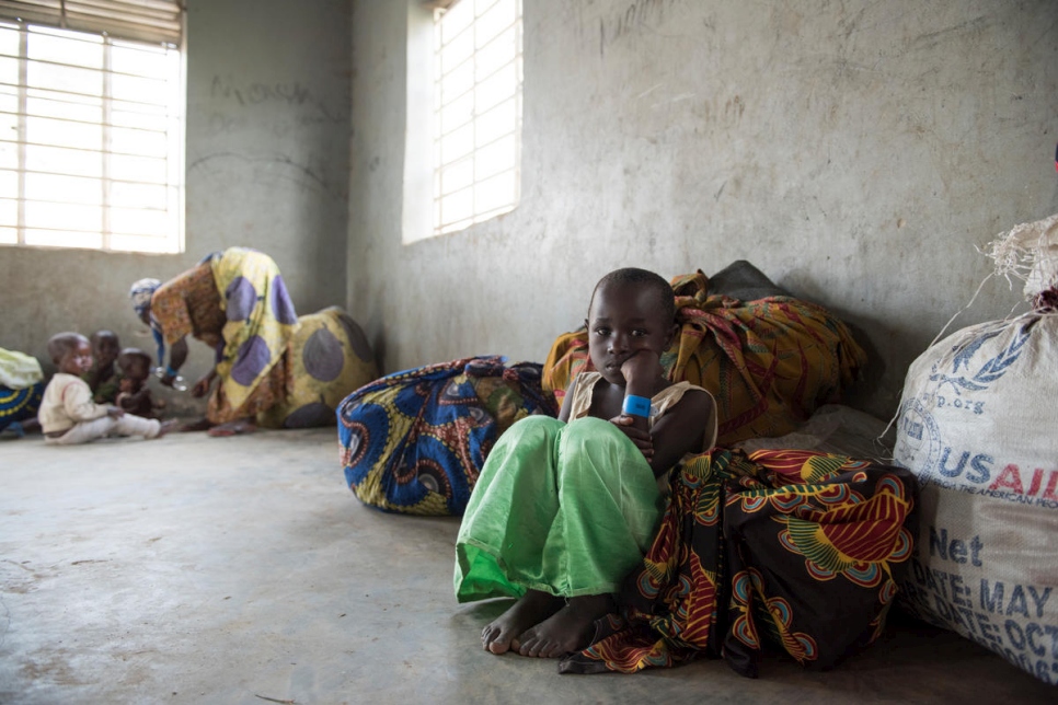 Uganda. Refugees children sit among the families belongings in their temporary shelter after their arrival from the border of DRC via Nyakabande transit centre