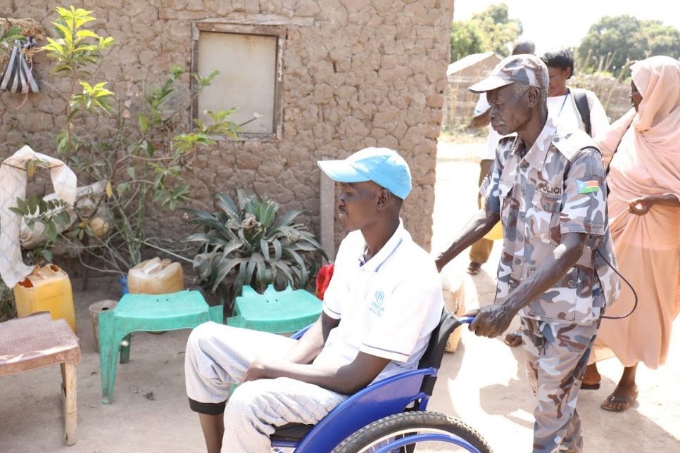 Zaki's father and policeman, 63-year-old Sebit Benoro, wheels him into his home in Wau, South Sudan. 