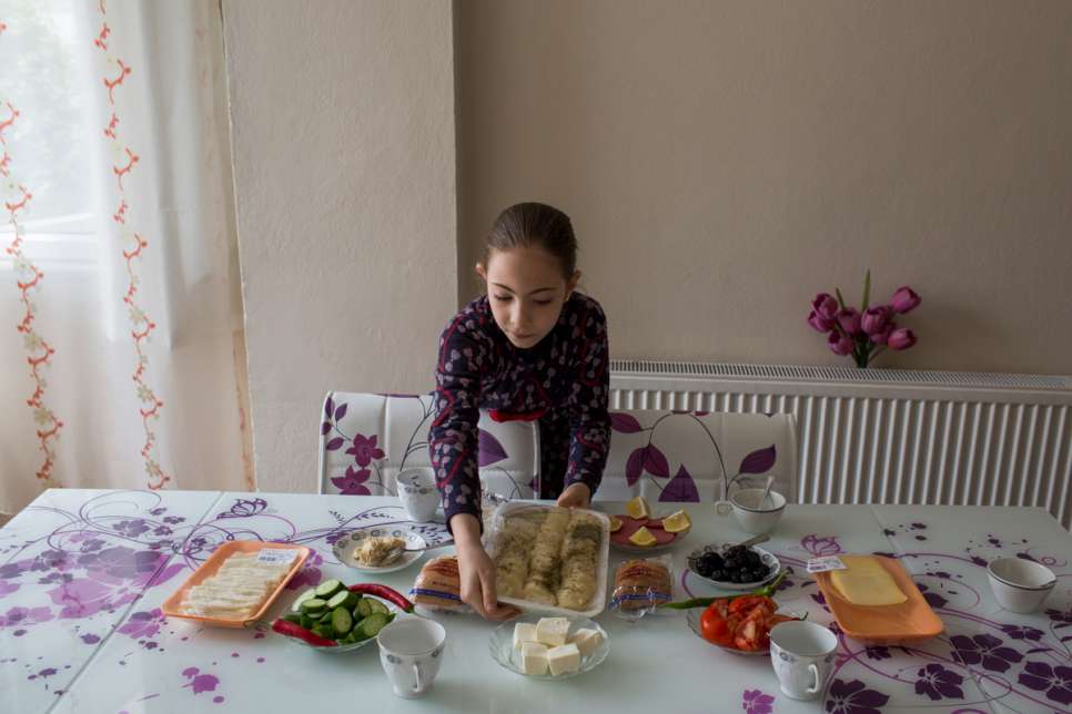 Mayas helps her mother, Darie, prepare breakfast at the apartment where they live in Istanbul. 