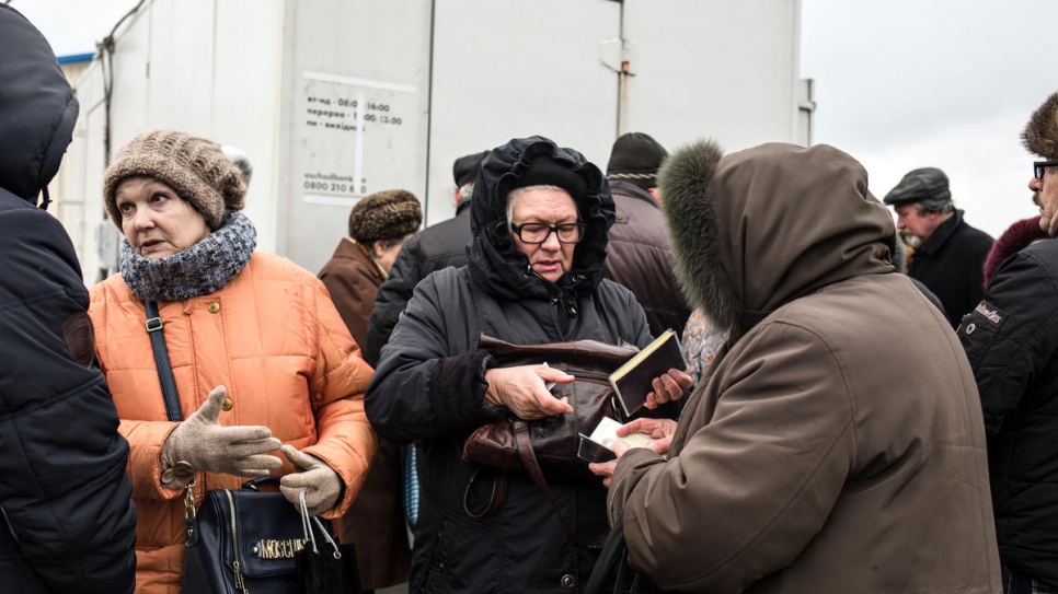 Des personnes âgées passent le point de contrôle de Novotroitske pour aller percevoir leurs pensions. 