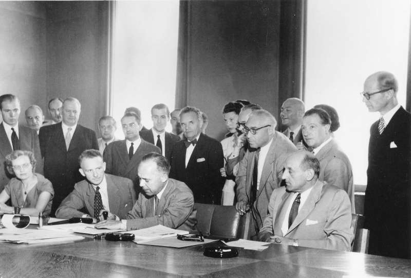 Signature of the 1951 Refugee Convention in Geneva, Switzerland /the three seated men (l-r): Mr. John Humphrey, Director of the Human Rights Division; Mr. Knud Larsen (Denmark) President of the Conference; Dr. G.V. van Heuven Goedhart, High Commissioner for Refugees /  copyright Arni / UN Archives / August 1, 1951