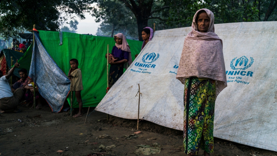 After fleeing violence in Myanmar, a Rohingya woman stands outside her tent at an informal settlement for new arrivals, near Kutupalong camp in Bangladesh.