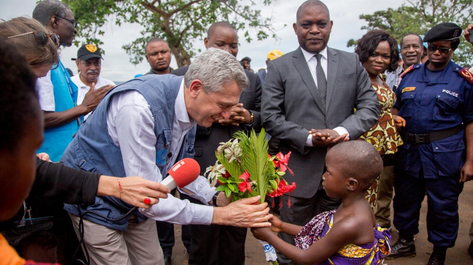 Une petite réfugiée burundaise accueille Filippo Grandi, le Chef du HCR, dans le camp de réfugiés de Mulongwe, au Sud-Kivu, en RDC.  