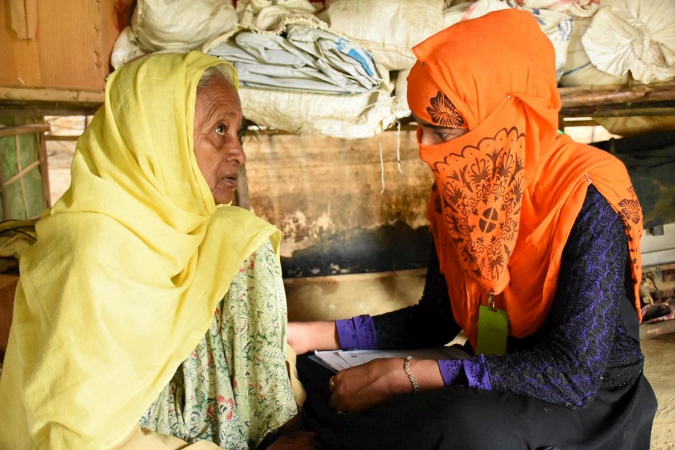 Formin (à droite), réfugiée rohingya et agent de santé communautaire, apporte écoute et soutien à Hanibi, âgée de 70 ans. 