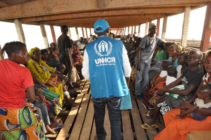A UNHCR staff member, Baudelaire, makes a final roll-call before departure. 