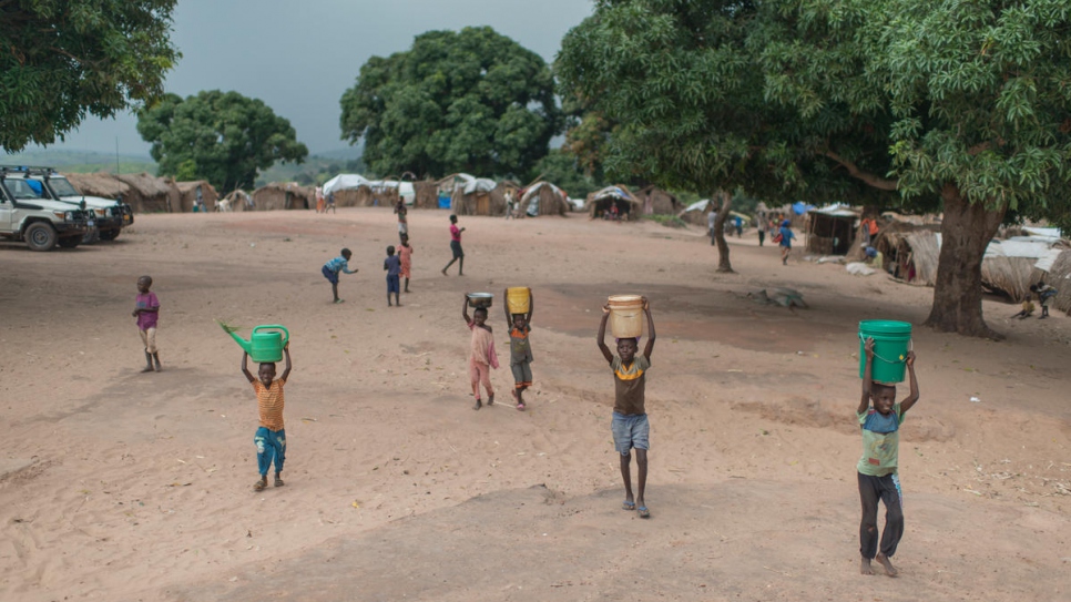 Des enfants congolais rapportent de l'eau vers leurs abris à Kaseke, un site qui accueille des déplacés internes dans la province du Tanganyika déchirée par la guerre. 