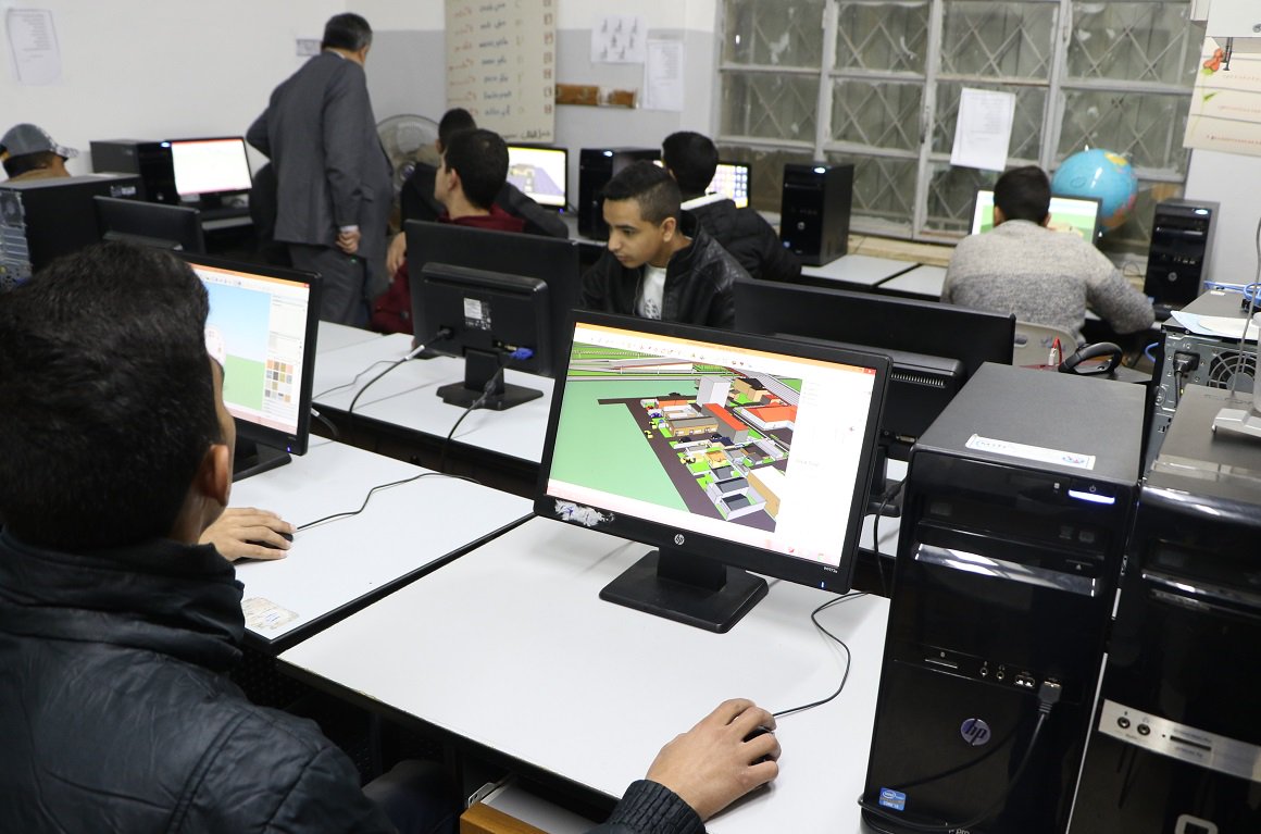 A crowded room of adolescents busy at their computers in school