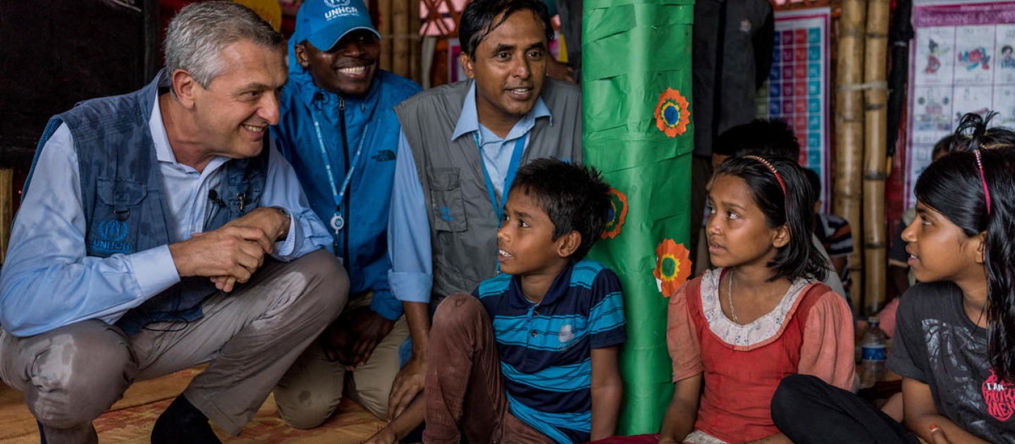 Le Haut Commissaire des Nations Unies pour les réfugiés Filippo Grandi (à gauche) discute avec des enfants réfugiés rohingyas dans un centre d'apprentissage du camp 4 de Kutupalong, au Bangladesh, le 3 juillet 2018.