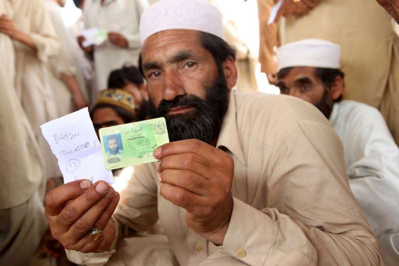 Pakistan / Sheikh Yasin camp / An IDP man shows his national ID card and names before being assigned a UNHCR-WFP ration card which will allow him and his family to have access to assistance in the camp. UNHCR and the government have established 89 registration points in NWFP. 1.4 million people have been displaced since May 2, following fighting between governmental troops and Talibans in the Swat, Lower Dir and Buner districts. / Mardan district, May 17, 2009