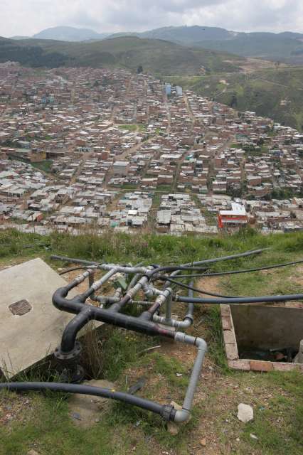 Services in the <em>barrios</em> are usually sub-standard at best. Here, in Los Altos de la Florida, tubes running from a big tank secured at the top of the hill bring water to hundreds of houses, but only for a few hours each day.