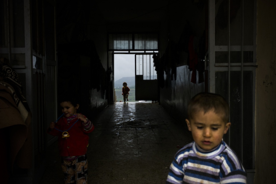 Young Yazidi children run around inside their temporary accommodation in Amadi, in northern Iraq, after fleeing fighting in Sinjar.