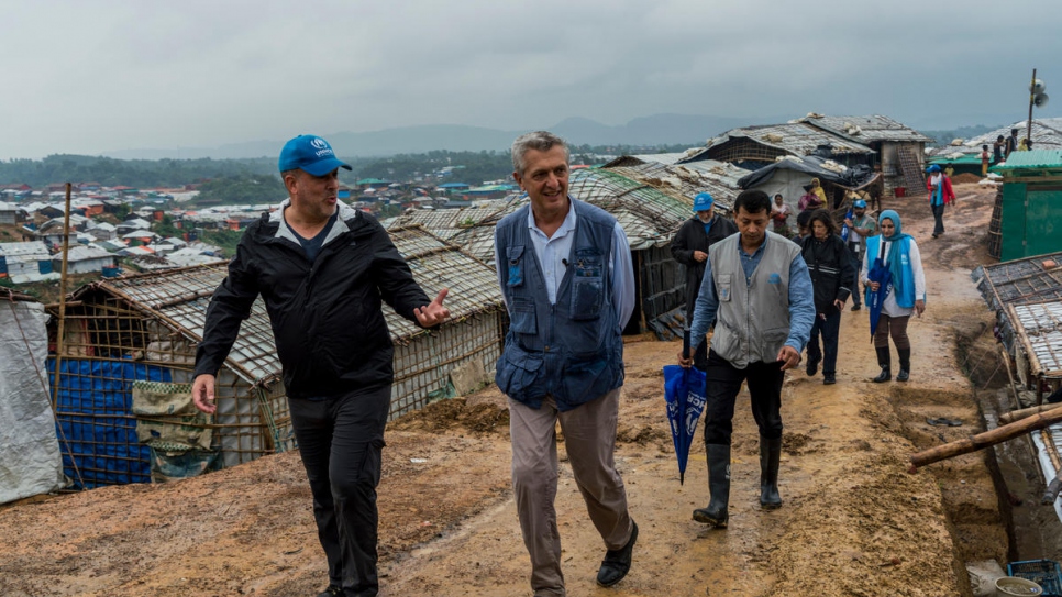 Le Haut Commissaire des Nations Unies pour les réfugiés, Filippo Grandi (à droite) est accompagné par un employé du HCR, tandis qu'il visite le camp 4 de Kutupalong, au Bangladesh, le 3 juillet 2018.