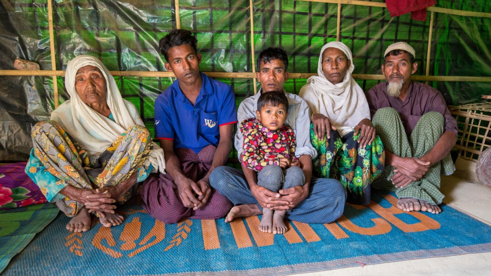 Gul Zahar, 90, Mohammad Siddiq, 25, Mohammad Ayub, 31, Kismat Ara, 3, Ayesha Begum, 40, and Oli Ahmed, 53, sit in their one-room shelter in Bangladesh.