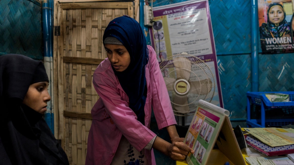Midwife Shirin Akter, 21, teaches Romida Begue, 25, a pregnant Rohingya mother of two, about her health during pregnancy at a primary health care facility funded by UNHCR and UNFPA in Bangladesh.