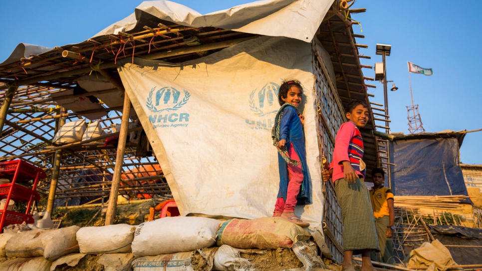 Rohingya refugee children stand outside a shelter being reinforced against monsoon rains in Kutupalong settlement, Bangladesh.