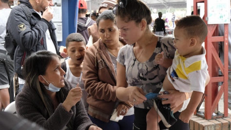 Mujeres y niños se encuentran entre los Venezolanos que cruzan el puente internacional de Rumichaca, el principal punto de ingreso a Ecuador desde Colombia, noviembre de 2018. 