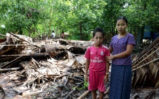 Ma Nge et son fils de 10 ans se tiennent devant les décombres de leur maison dans un petit village de la région de Ponnagyun, dans l'Etat de Rakhine. Le cyclone Komen avait fait tomber un arbre qui a détruit leur maison.