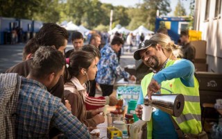 Syrian volunteer Hamad laughs as he doles out hot tea for refugees trying to stave off dropping temperatures in Austria.