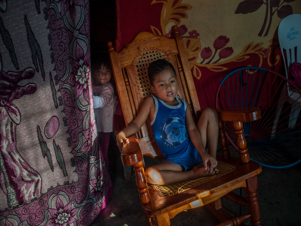 A young member of the Pérez family, who was forced to flee El Salvador, sits in his new home in the southern state of Chiapas, Mexico. © UNHCR/Daniele Volpe