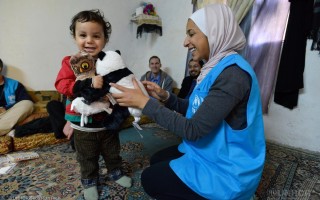 Baby Mawther eighteen months recieving toys as gifts from IKEA during a home vist by UNHCR syaff and a team from IKEA norway . This is the Sulimain family. Amman Jordan