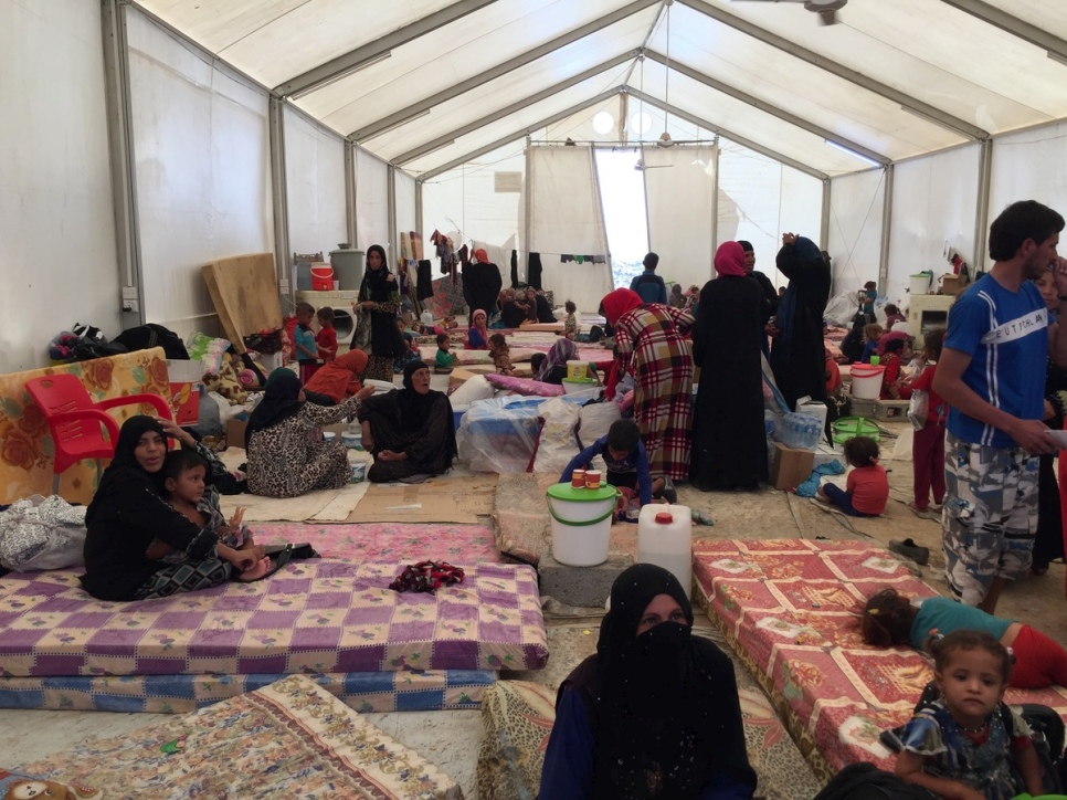 Women wait for their husbands to be security screened before they are allocated individual family tents at Debaga camp in the Kurdistan Region of Iraq. © UNHCR/Caroline Gluck