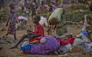 Un jeune réfugié soudanais est assis sur un sac de vêtements au centre de réception de Dzaipi dans le nord de l'Ouganda.