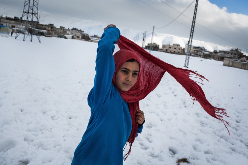 Asma'a, 12, fixes her headscarf outside her family's shelter in the Bekaa Valley, Lebanon.  