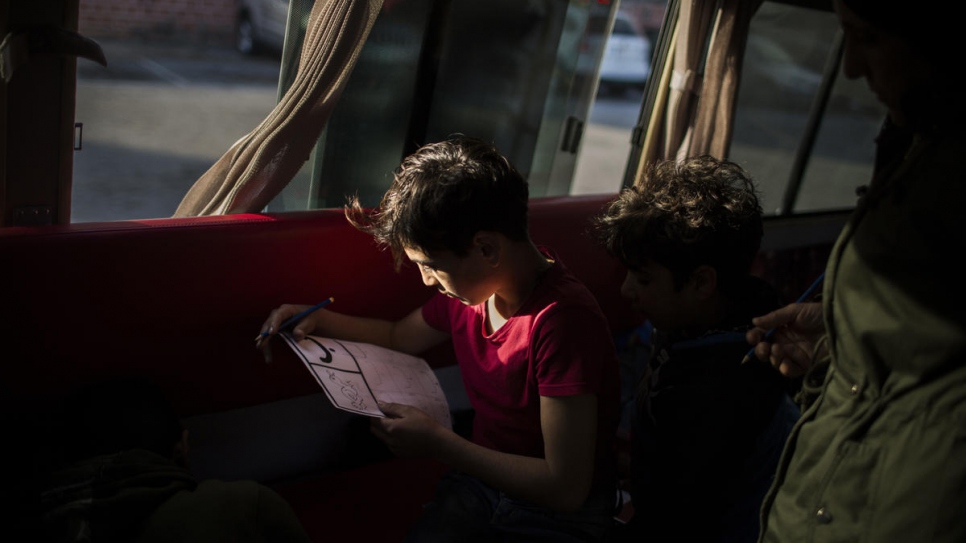 A child learns to read during his weekly visit onboard the bus.