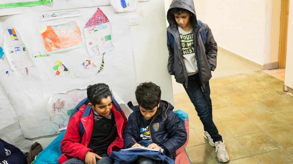 Trois jeunes élèves font leurs devoirs pendant une pause. 