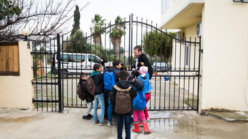 Les enfants échangent avec l'un de leurs professeurs après une journée de cours. 