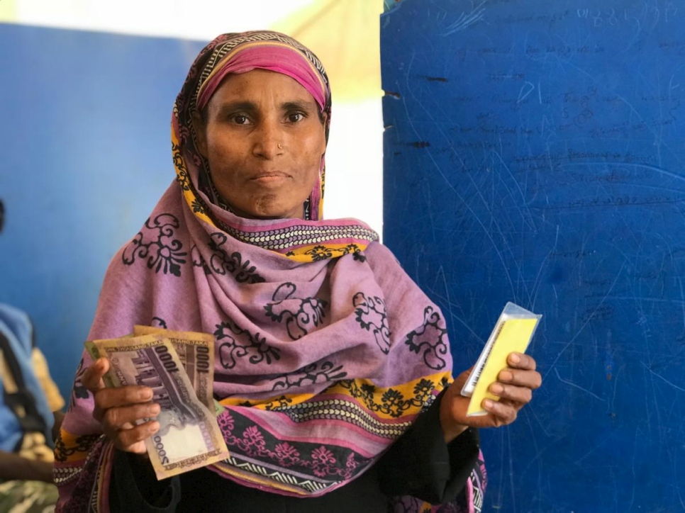 اللاجئة الروهينغية والأم العزباء، سامودا، 35 عاماً، تحصل على مساعدة نقدية من المفوضية في بنغلاديش، أبريل 2018. تقول: "أول شيء سأقوم به هو تسديد ديوننا ومن ثم سأستخدم هذا المال لشراء الطعام".