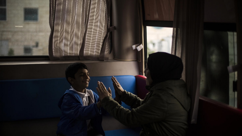 A young Syrian refugee plays with one of the outreach volunteers who works on the bus. 