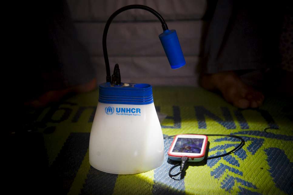 A Syrian refugee shows how the IKEA-donated lamp also doubles as a mobile phone charger in Azraq Refugee Camp, Al Azraq, Jordan.