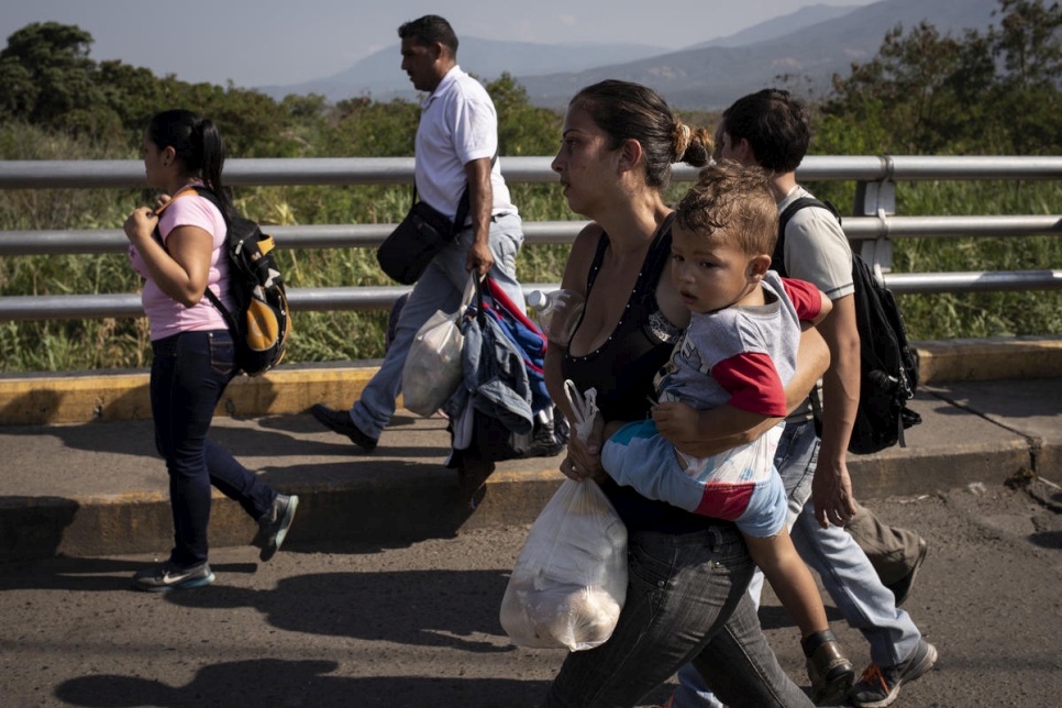 Une ressortissante vénézuélienne porte son enfant alors qu'elle emprunte le pont Simon Bolivar vers la Colombie. Janvier 2019. 