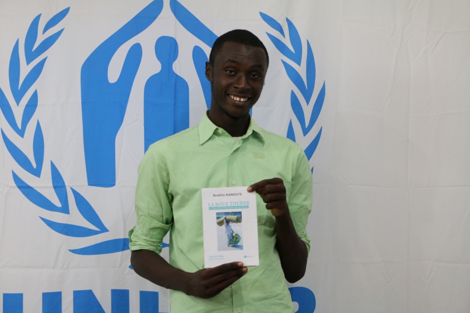 Ibrahim Kanoute pose avec son livre 'La Roue Tourne' au bureau du HCR à Bamako, au Mali.