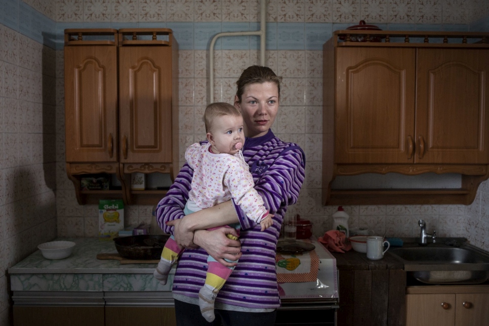 Olena dans son appartement, près de la ligne de contact, avec sa fille Yelyzaveta, 7 mois.