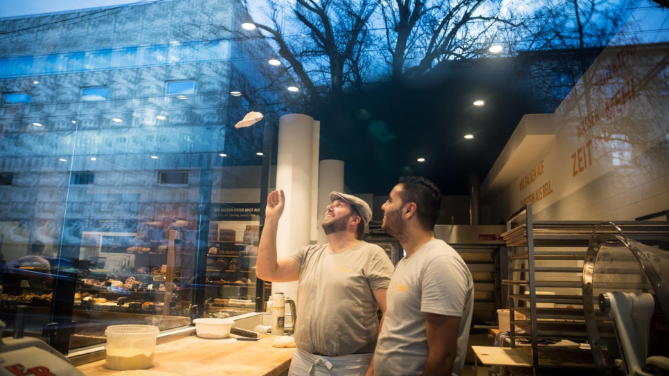 Björn teaches Mohamad the basics of breadmaking in his on-site bakery.