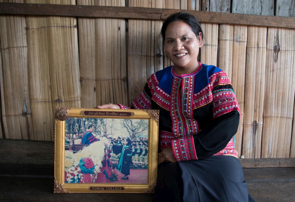 ناتي، امرأة كانت عديمة الجنسية سابقاً من قبيلة لاهو، تحمل صورة تخرجها من الجامعة.