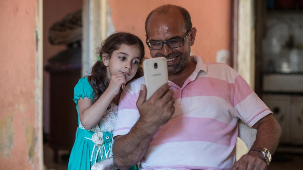 Zain's father Ali and sister Riman smile as they talk to a cousin already living in the Norwegian town of Hammerfest.