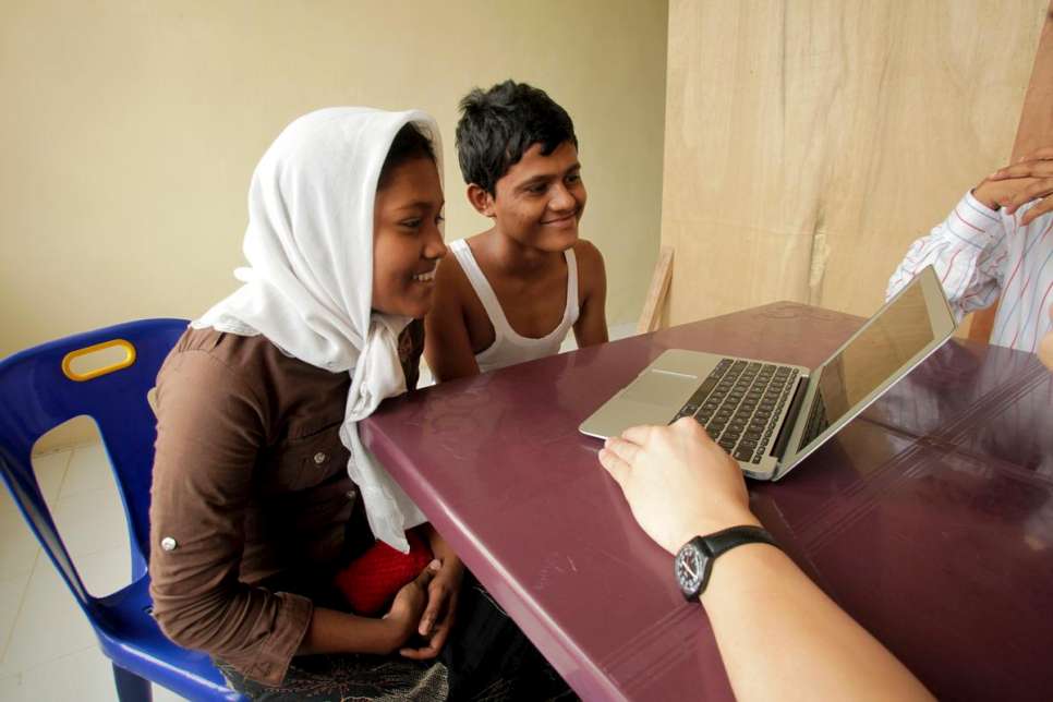 In Aceh, Indonesia, UNHCR staff show Ali, 18, and Shahida, 14, a photograph of their mother and younger brother in Malaysia.