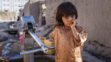 An Internally Displaced girl pumps water near her family's mud house in Minarets informal settlement in the center of Herat city. Families in this urban settlement fled their homes around the year 2000 for security reasons. ; Families settled in 2000, the provincial governor at the time gave permission to settle here but no formal documents were given. Recently the IDP's have been facing eviction threats.