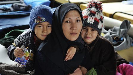 Mother with her son and daughter, from Iran seeking asylum in Austria, in a temporary family accommodation at Asfinag. The Asfinag centre is on the former site of a roadworks company, on the outskirts of Salzburg, a short distance from the border with Germany. Refugees and migrants arrive here directly by bus from the Slovenian border, brought by the Austrian authorities, and most will move on to Germany, and are accommodated in heated tents with camp beds and blankets. For those seeking asylum there are more permanent structures, with family groups separated from single males. Food is provided by volunteers three times a day. ; More than 643,000 refugees and migrants arrived in Europe via the Mediterranean sea this year, including 502,500 in Greece only. Many of the refugees and migrants are desperate to move quickly onwards to Western Europe, fearing that borders ahead of them will close. Although reception capacities have been stepped up the rising numbers has put the  Austrian reception system under strain. Many newcomers as well as transiting refugees and migrants are temporarily accommodated in sports- and music halls, former office buildings etc., with those wishing to stay waiting sometimes for weeks to get proper accommodation. With the winter approaching, aid has also been stepped up at the borders. At all border crossings where refugees are arriving or leaving – currently from Slovenia to Austria and from Austria to Germany – large heated tents which can hold up to a few thousand persons have been put up and NGOs, volunteers and authorities are providing basic services.