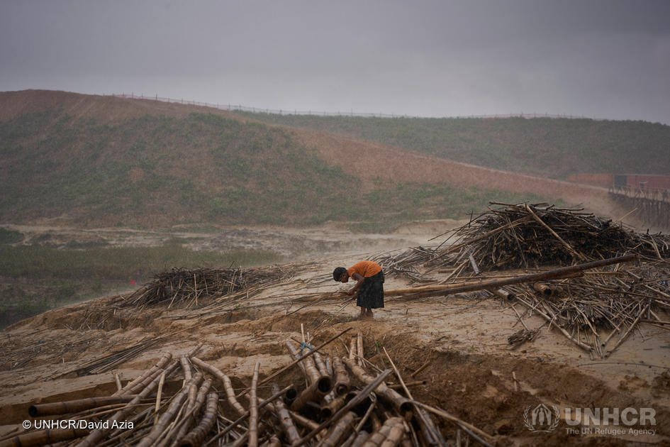 Bangladesh. A Rohingya refugee collects firewood during a heavy downpour