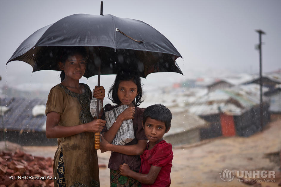 Bangladesh. Rohingya refugees walk through a heavy downpour