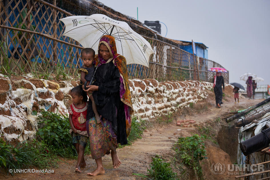 Bangladesh. Rohingya refugees walk through a heavy downpour