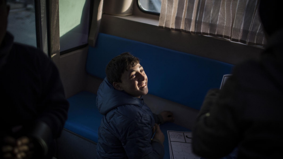 Alaa, un réfugié syrien originaire d'Alep et qui vend des bouteilles d'eau à un carrefour très fréquenté, apprend l'alphabet dans le « Fun Bus ». 