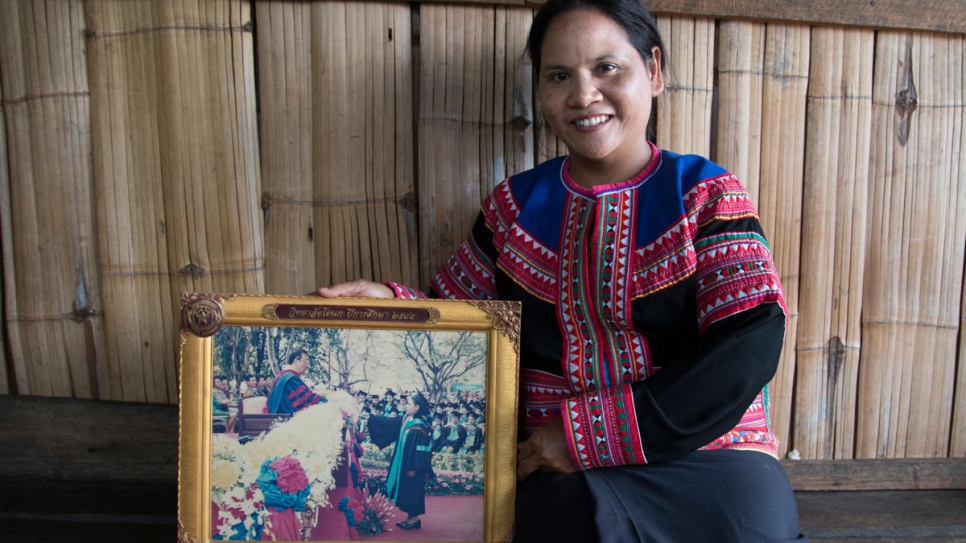 Natee, a formerly stateless woman from the Lahu hill tribe, shows a photograph of her university graduation 