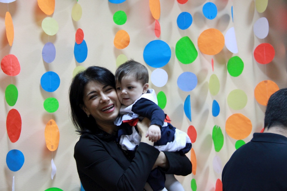 UNHCR Goodwill Ambassador Iskui Abalyan mets a family of resettled refugees in Gomel, Belarus in April 2016. During the mission, she visited the Temporary Accommodation Centre (TAC) to meet refugees from different countries (Ukraine, Syria, Georgia). This photo was taken with a Syrian family at the TAC. They were resettled under the first and the only joint resettlement project of UNHCR and the Ministry of Internal Affairs of Belarus. The family was resettled from Syria to Gomel in February 2015. 