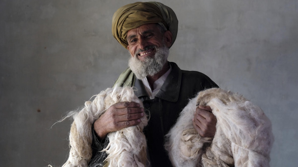 An Afghan returnee holds wool he sorts out for women spinners. The thread goes to make carpets and kilims as part of UNHCR's community based livelihoods project in Kabul, December 2017.