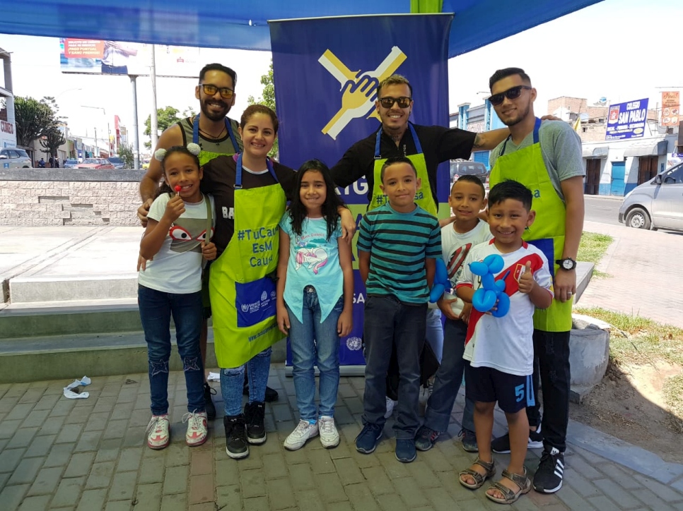Los estilistas de las ''Brigadas ¡Gracias Causa!'' en Tacna, Perú, con los niños y niñas de la comunidad.